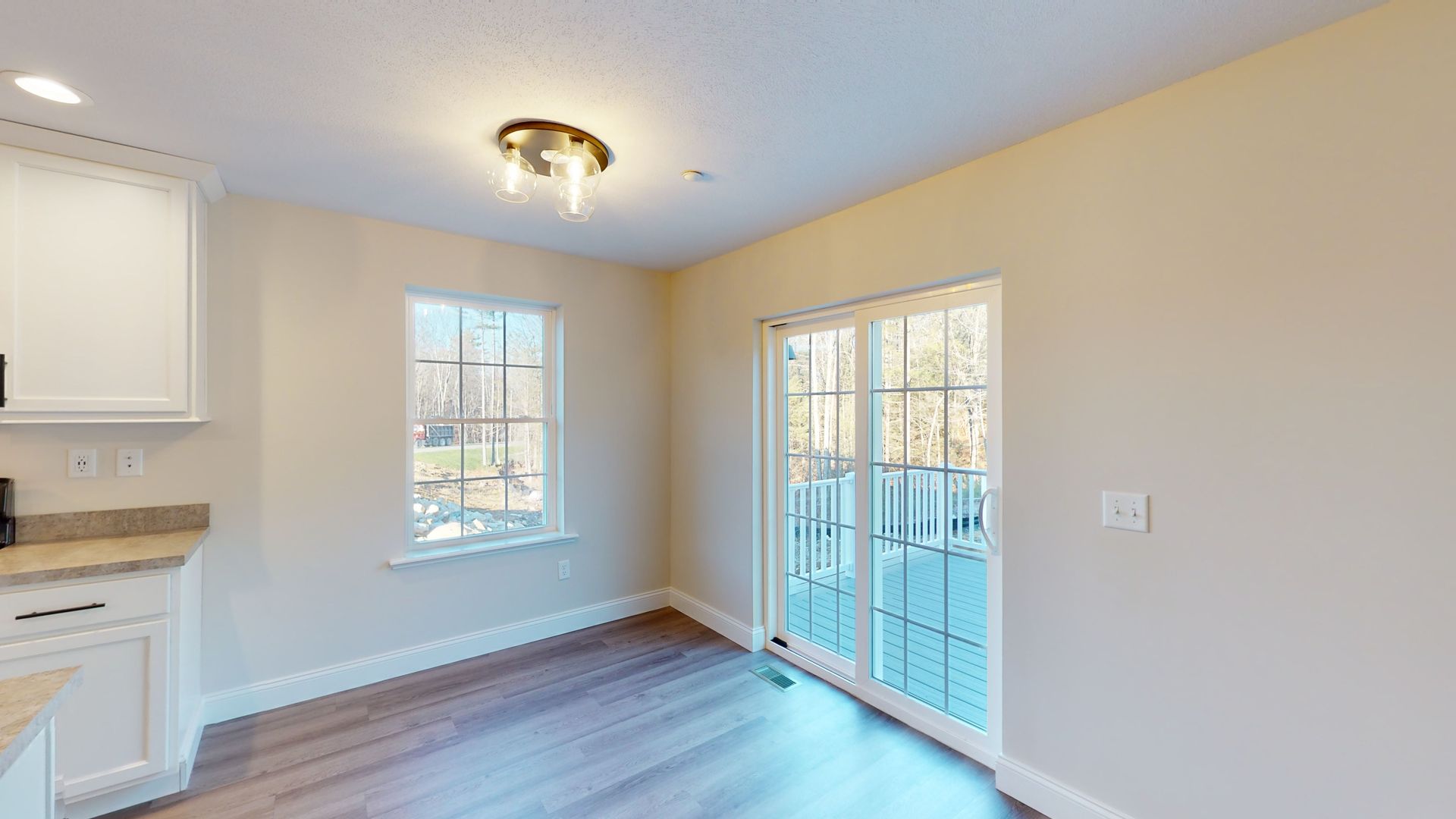 An empty room with a sliding glass door and a window.