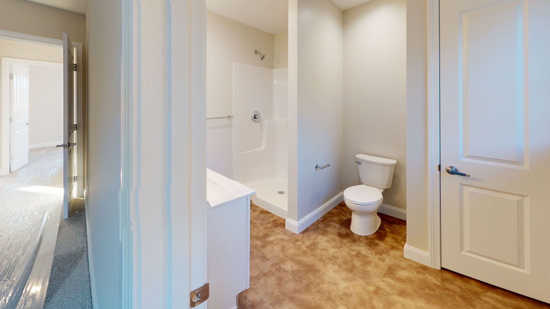 A bathroom with a toilet , sink , shower and walk in shower.