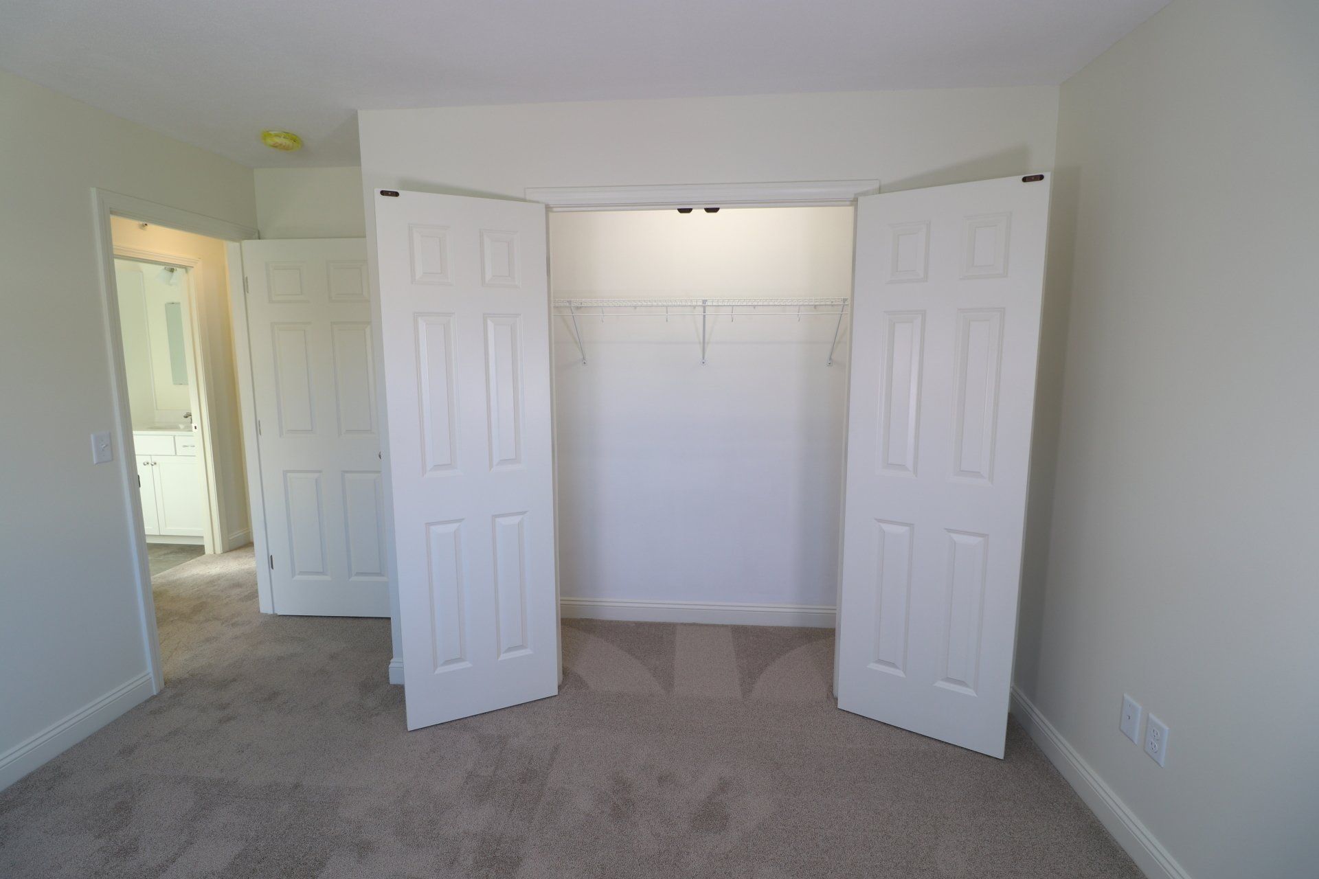 There is a closet in the middle of the room with the doors open.