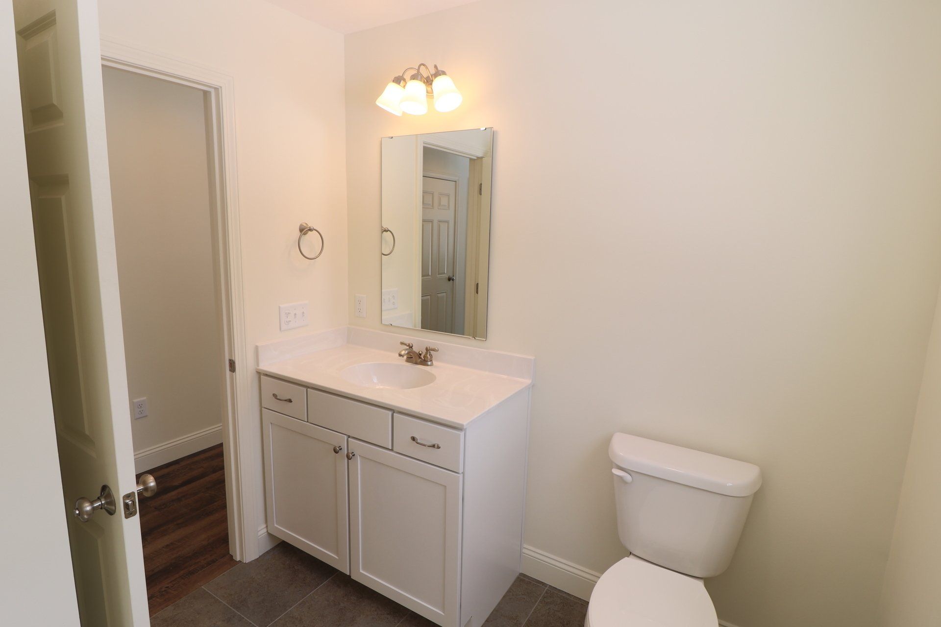 A bathroom with a sink , toilet and mirror.