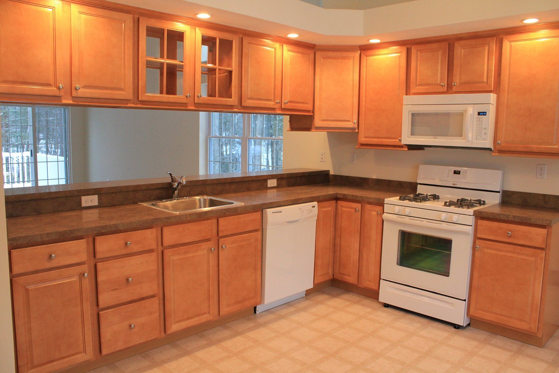 A kitchen with wooden cabinets and a white stove