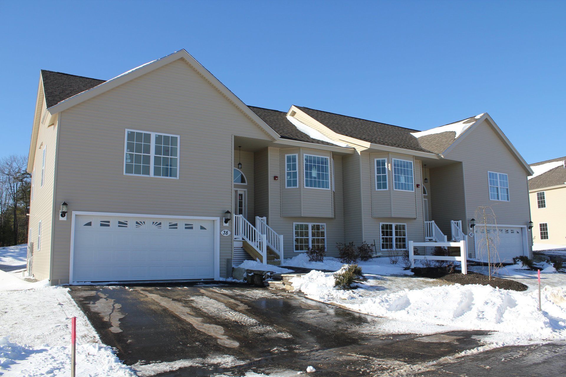 A house with a white garage door is covered in snow