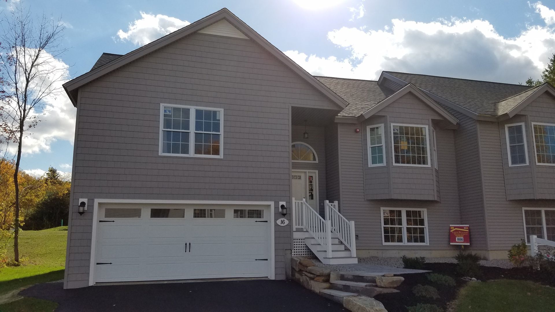 A large house with a white garage door and stairs