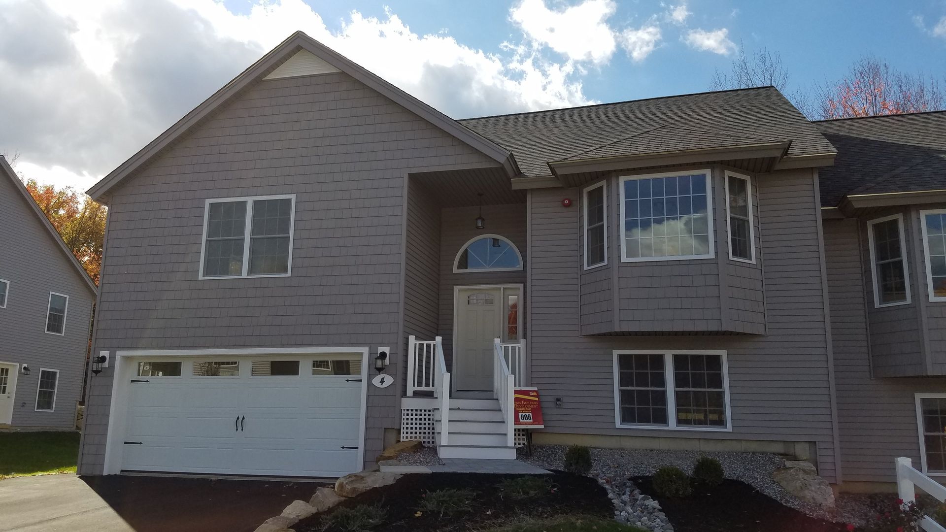 A large house with a lot of windows and a white garage door.