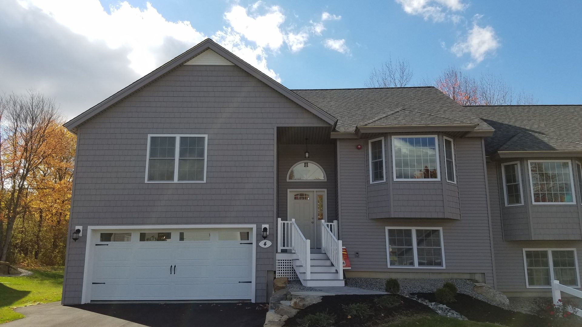 A large gray house with a white garage door