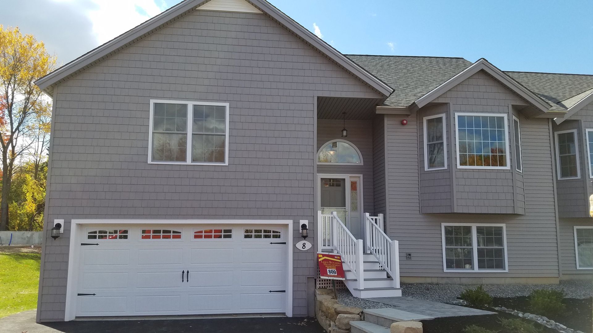 A large house with a white garage door and stairs