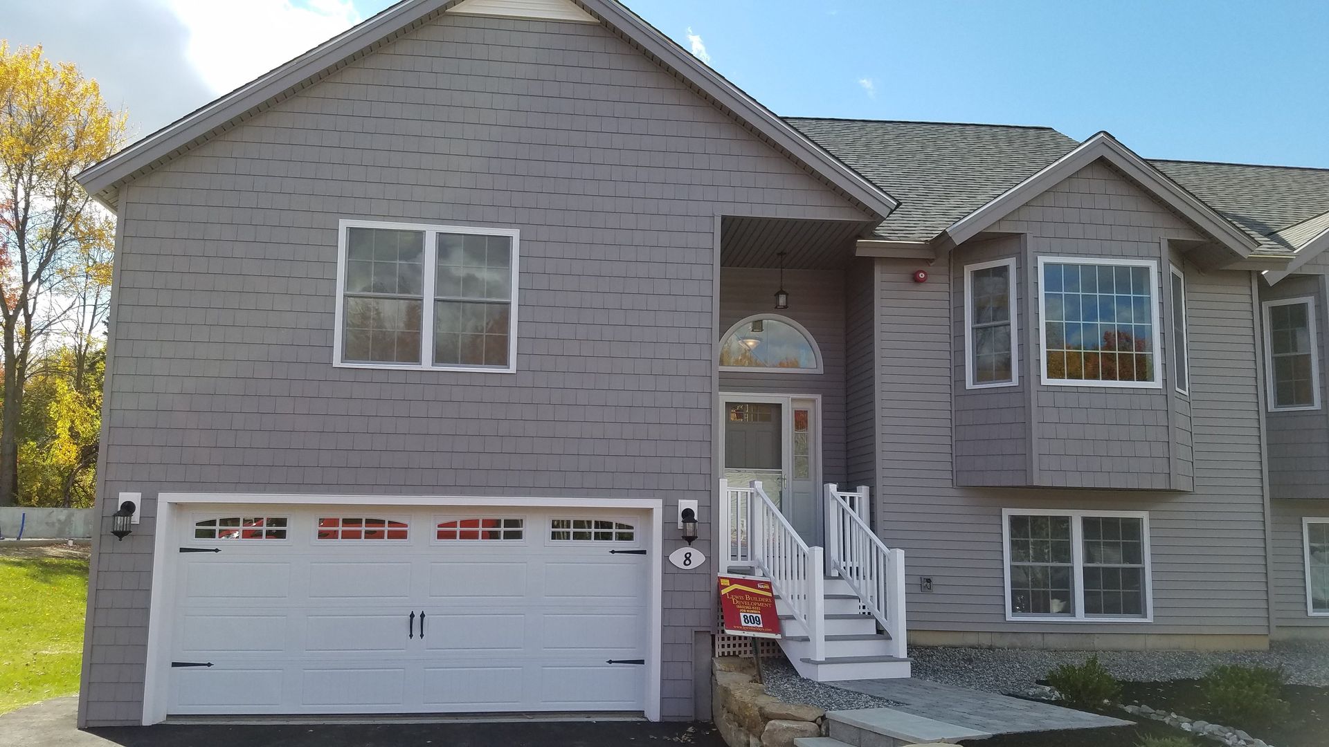 A large gray house with a white garage door