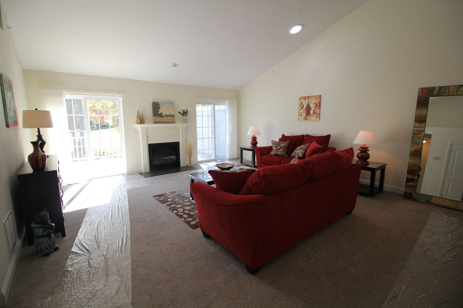 A living room with a red couch and a fireplace