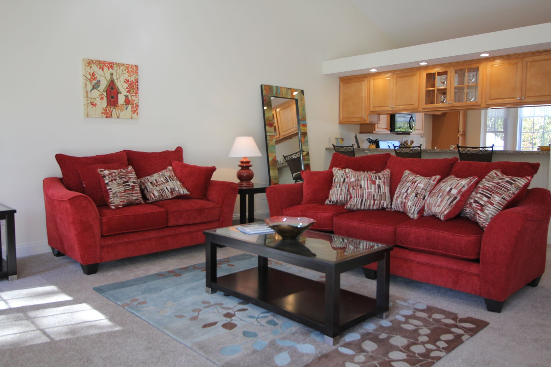 A living room with two red couches and a coffee table