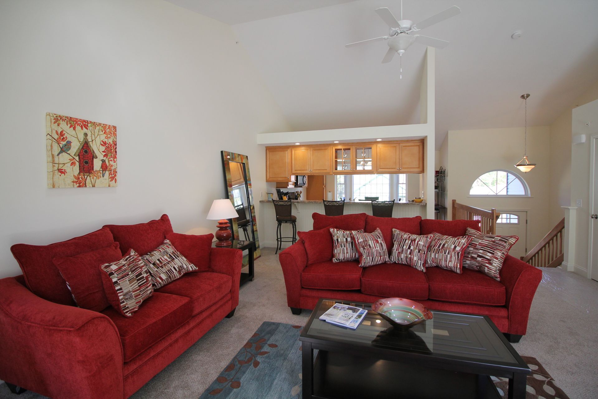 A living room with two red couches and a coffee table
