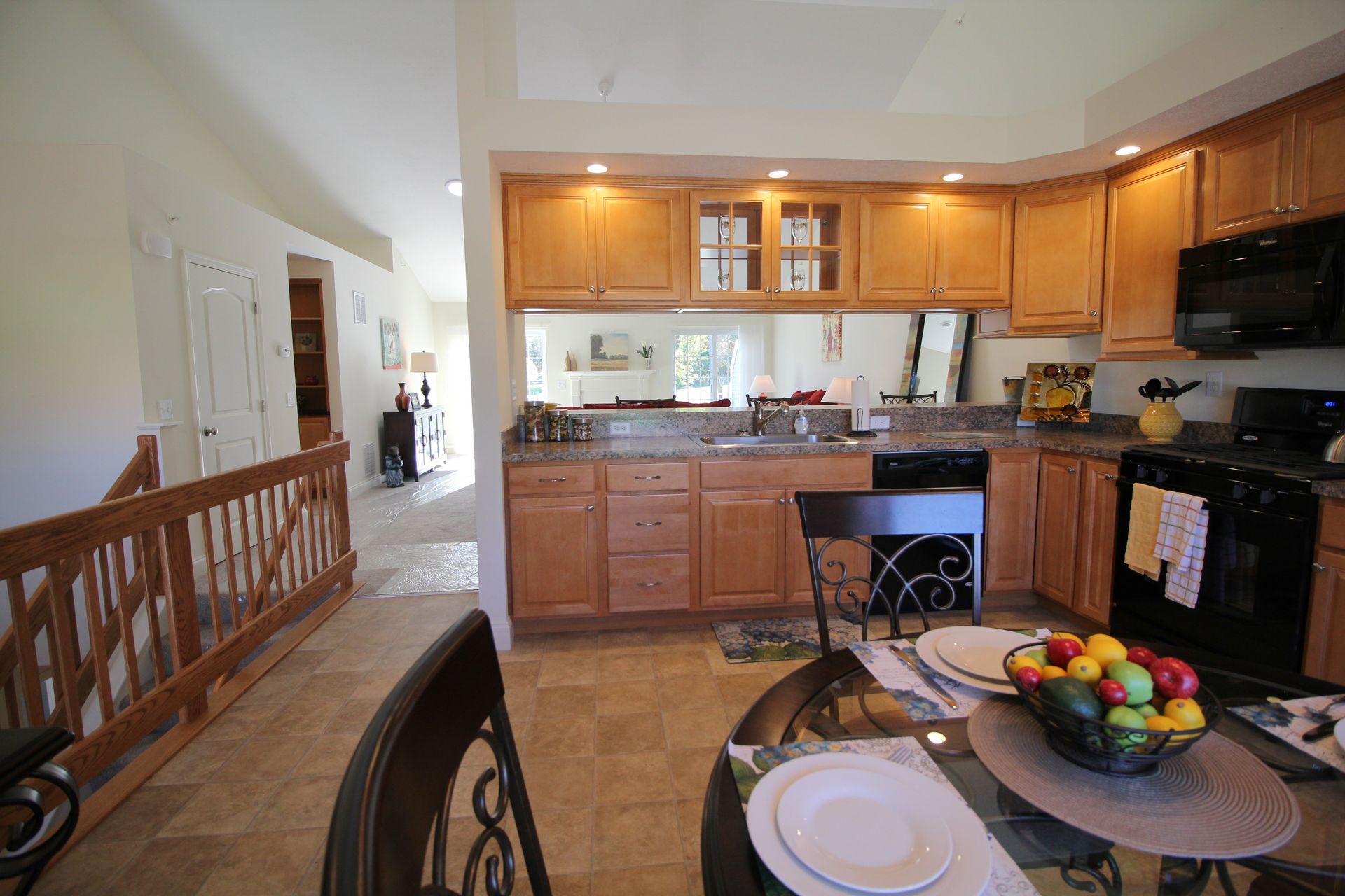 A kitchen with a table and chairs and a bowl of fruit