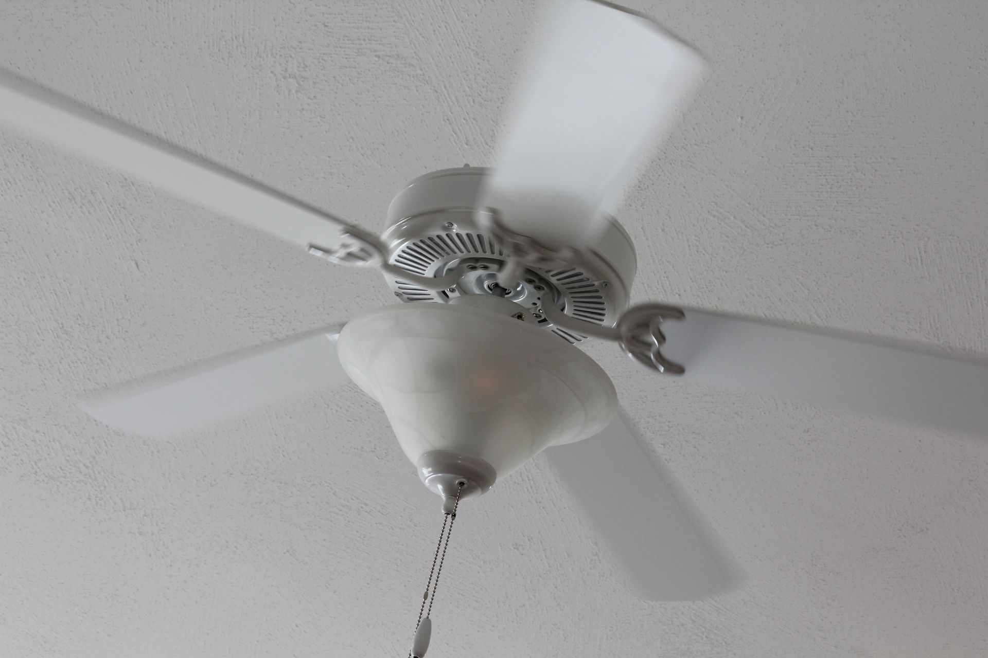 A white ceiling fan is hanging from the ceiling in a room.