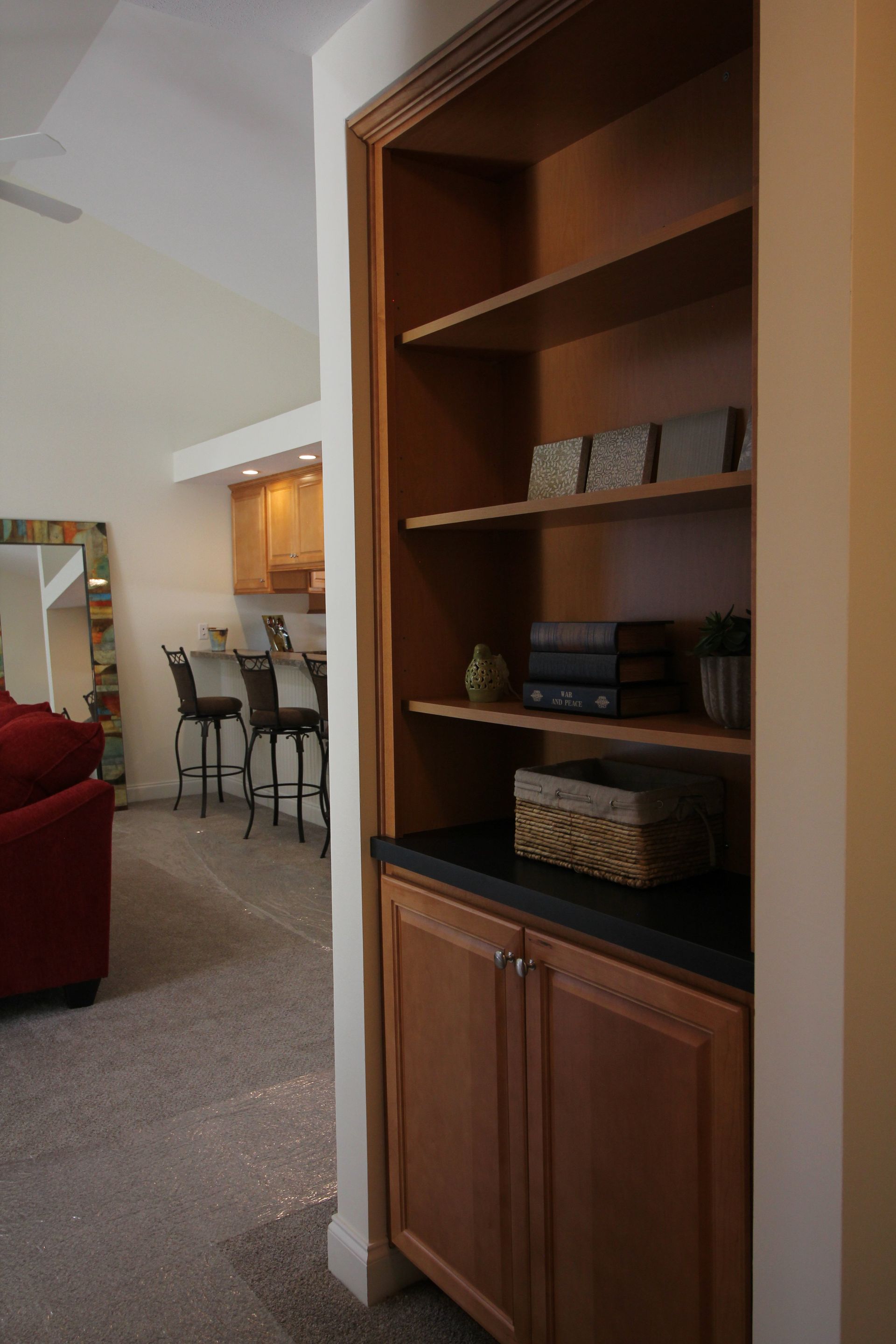 A living room with a red couch and a mirror