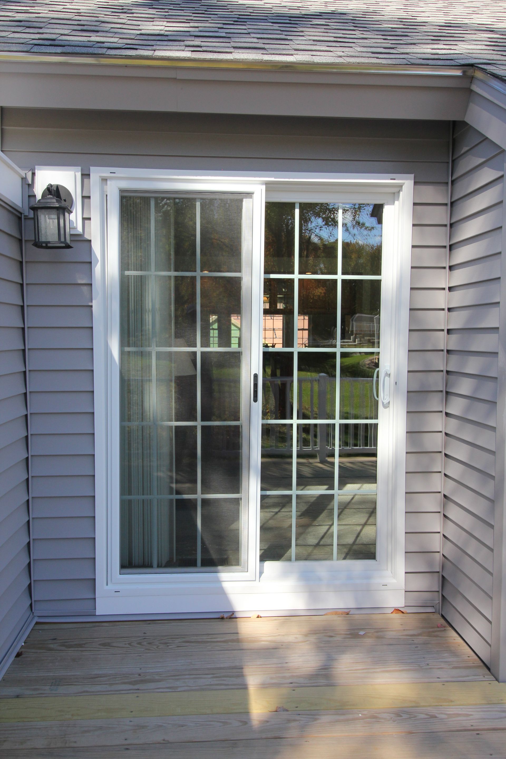 A white sliding glass door is open to a patio.