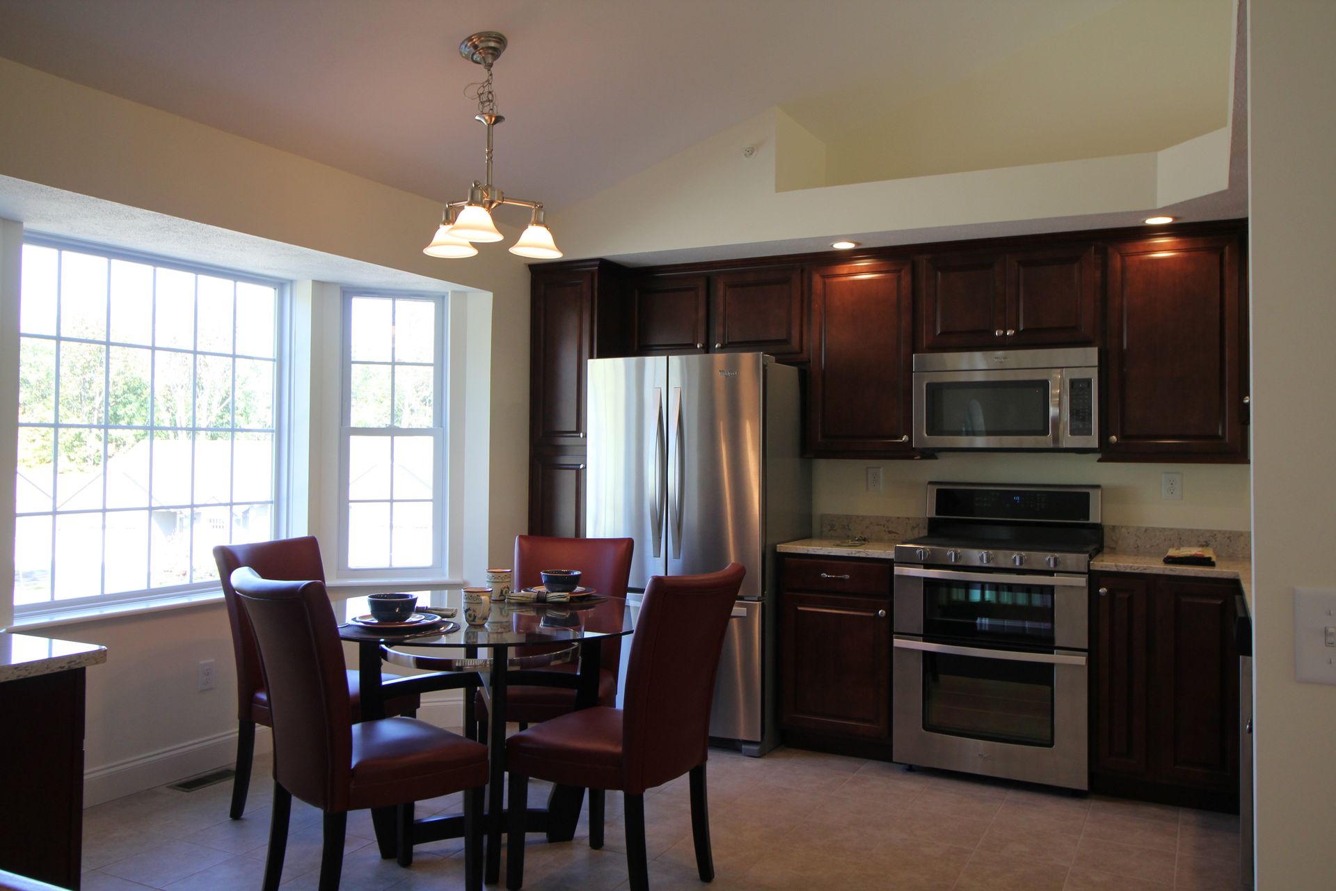 A kitchen with stainless steel appliances and a table and chairs