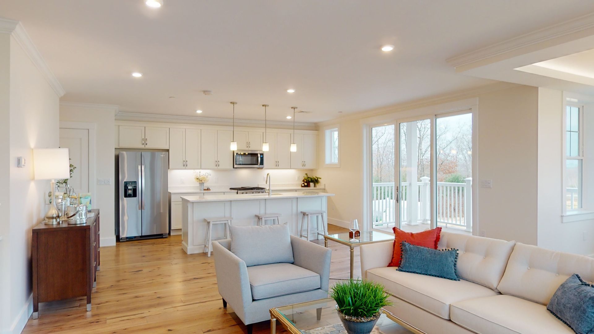 A living room with a couch , chair , coffee table and kitchen.