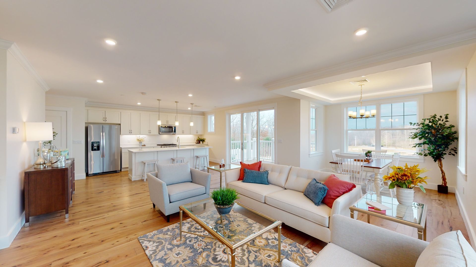 A living room with a couch , chairs , a table and a refrigerator.