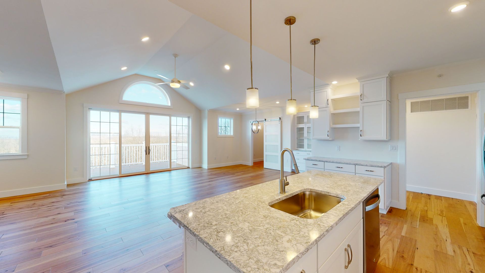 A kitchen with granite counter tops , stainless steel appliances , and hardwood floors.