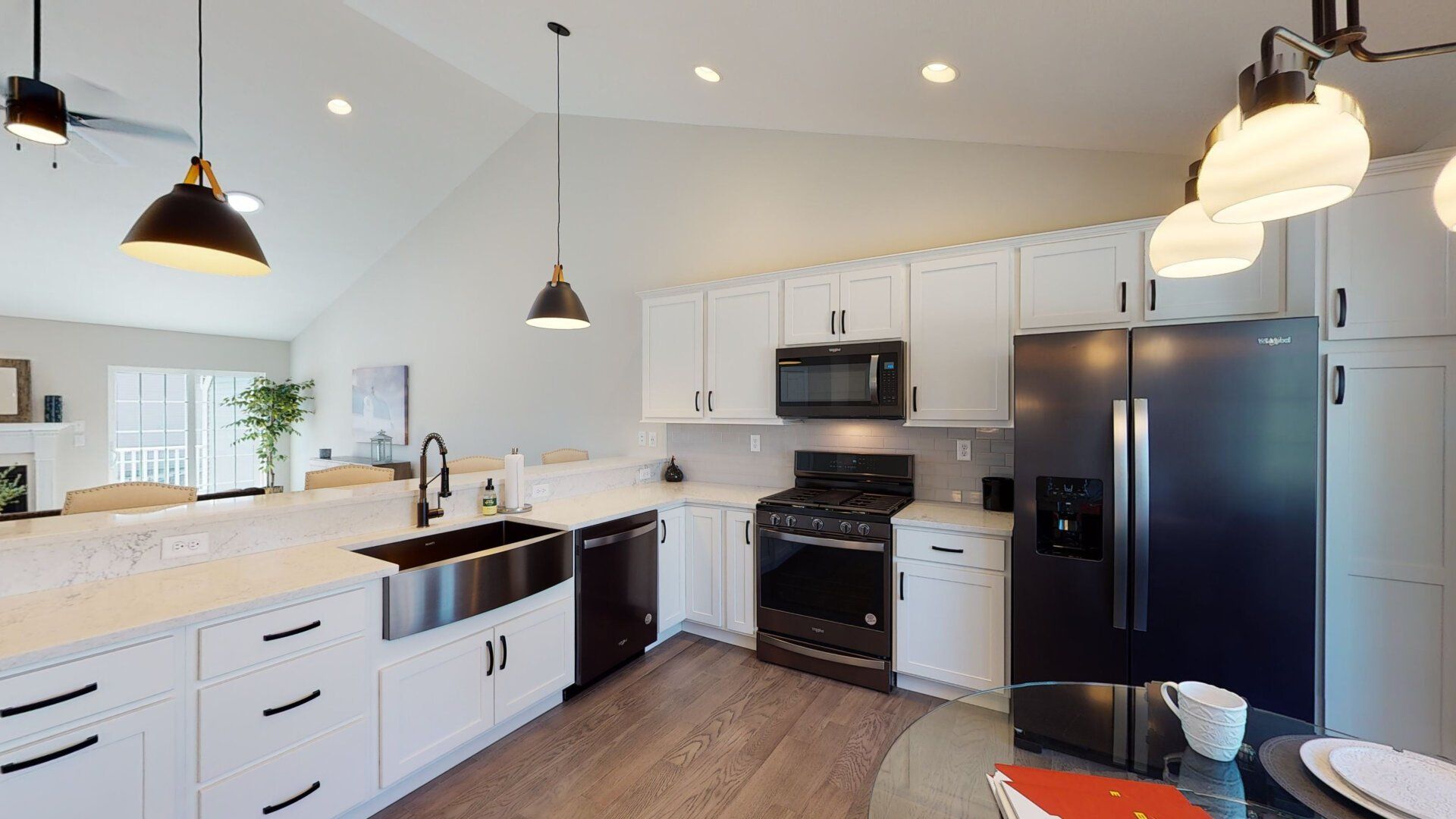 A kitchen with white cabinets and a black refrigerator