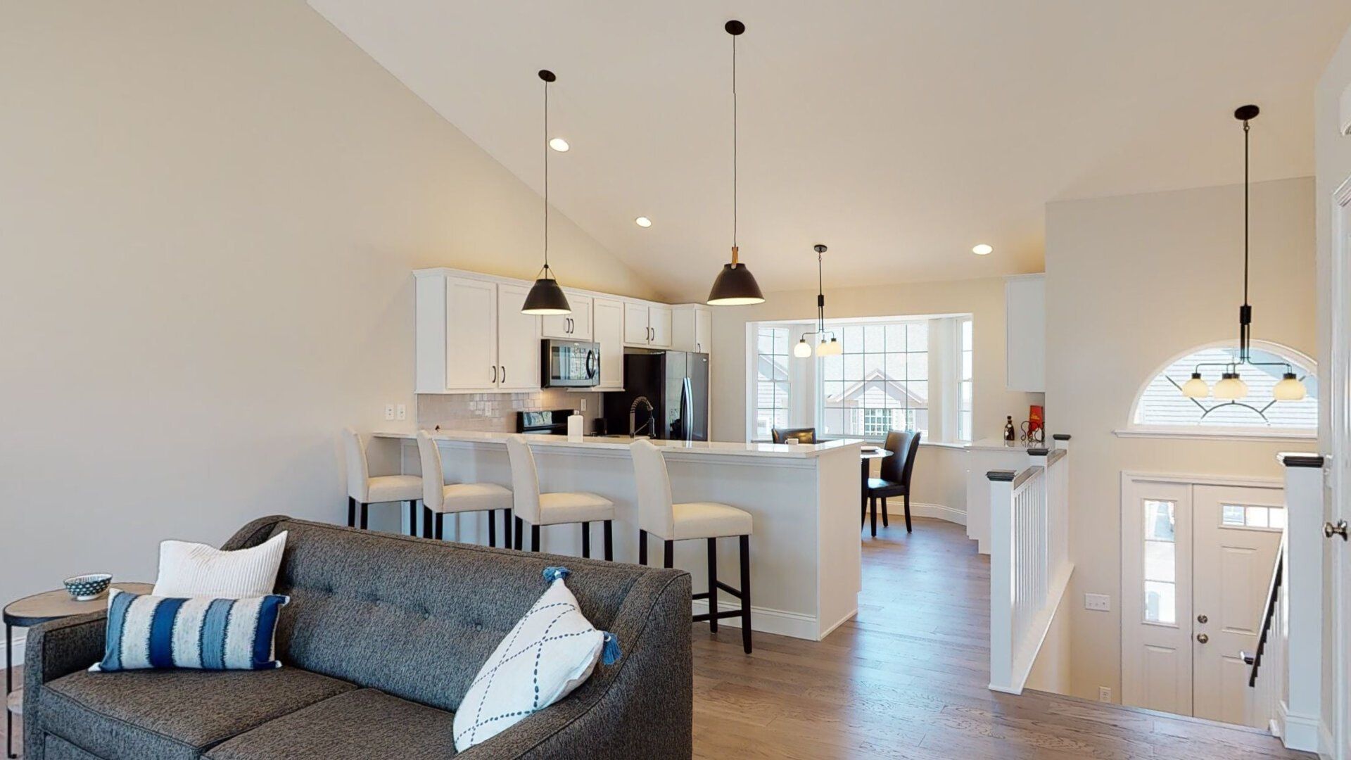 A living room with a couch and a kitchen in the background.