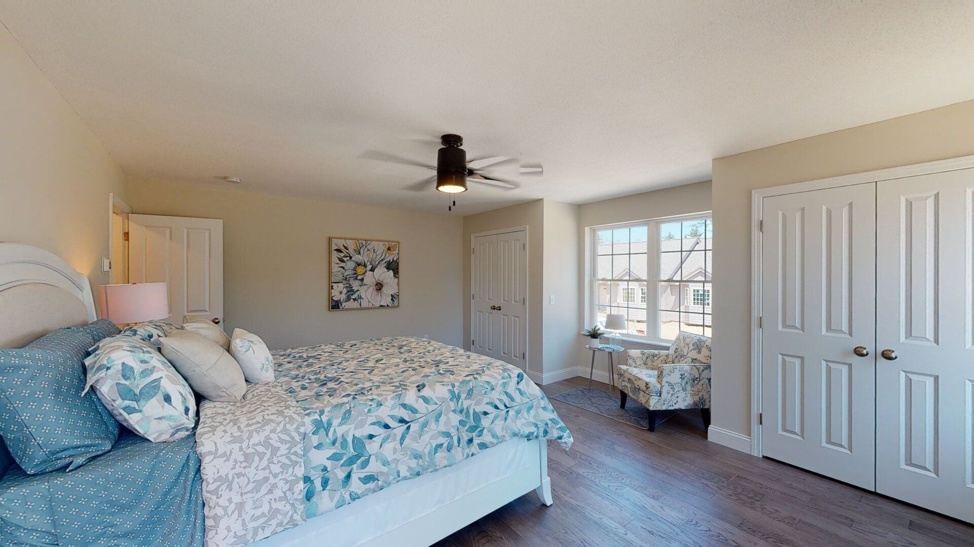 A bedroom with a large bed and a ceiling fan.