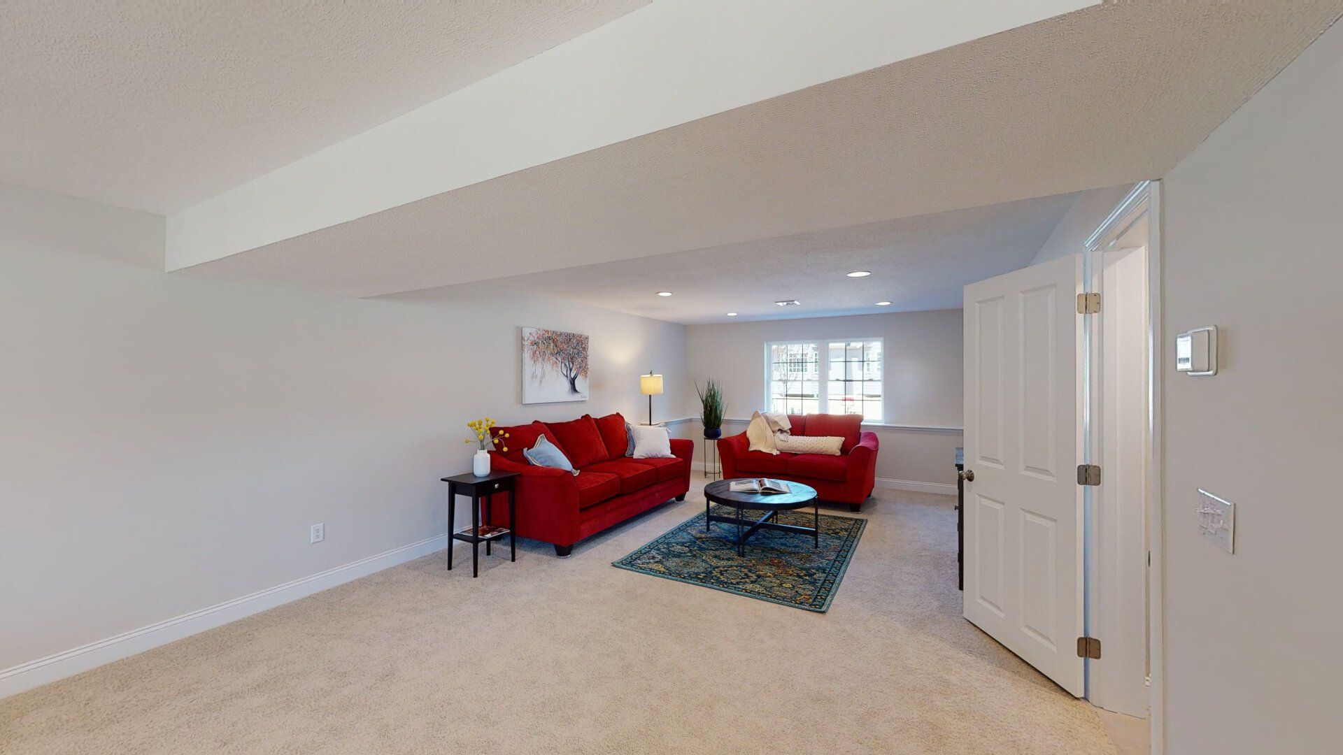 A living room with a red couch and a coffee table.