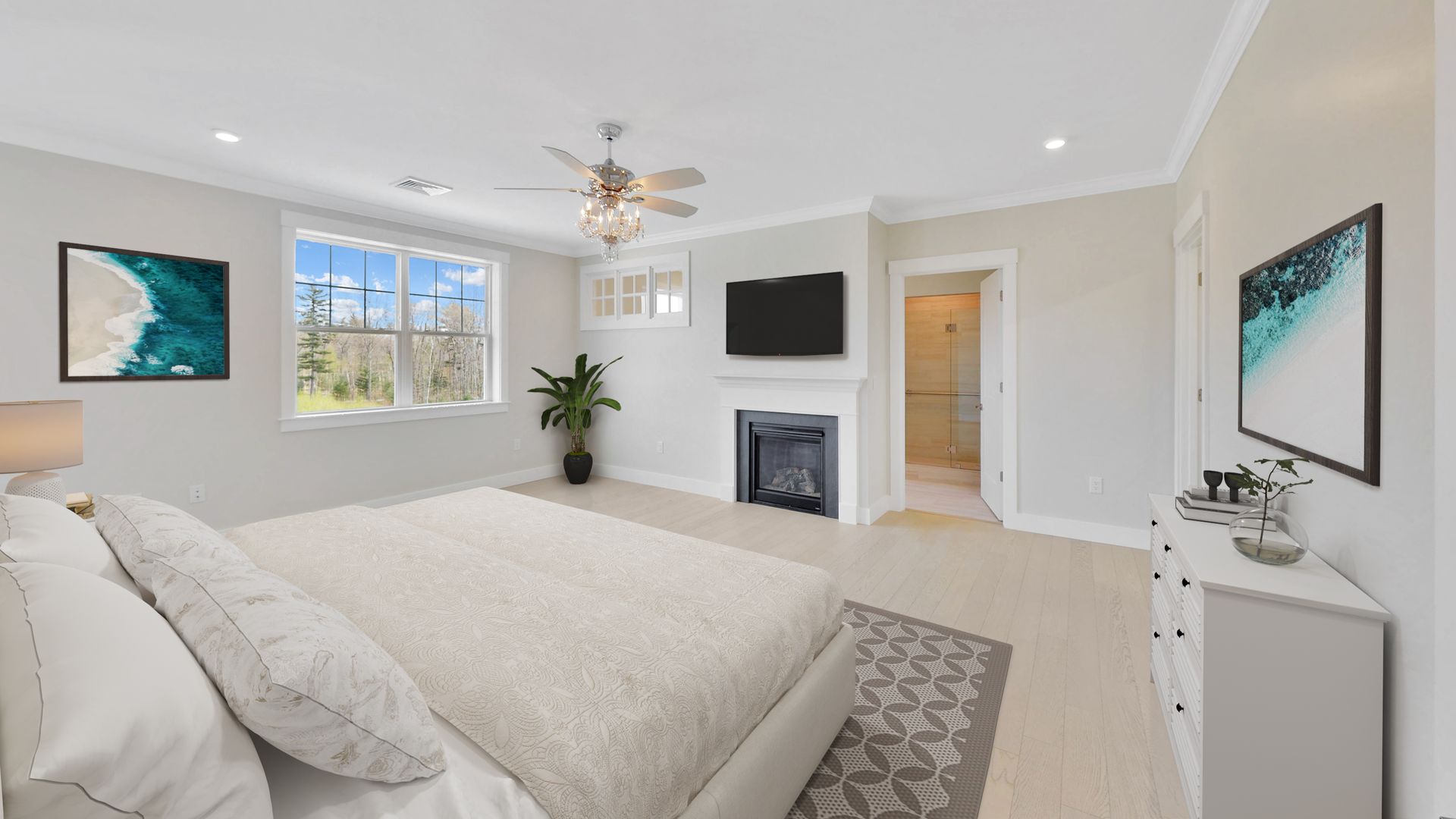 A bedroom with a large bed , fireplace , television and ceiling fan.