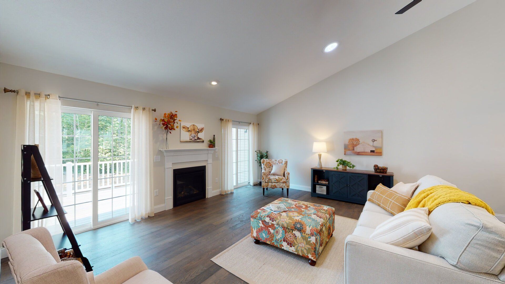 A living room with a couch , chair , ottoman and fireplace.