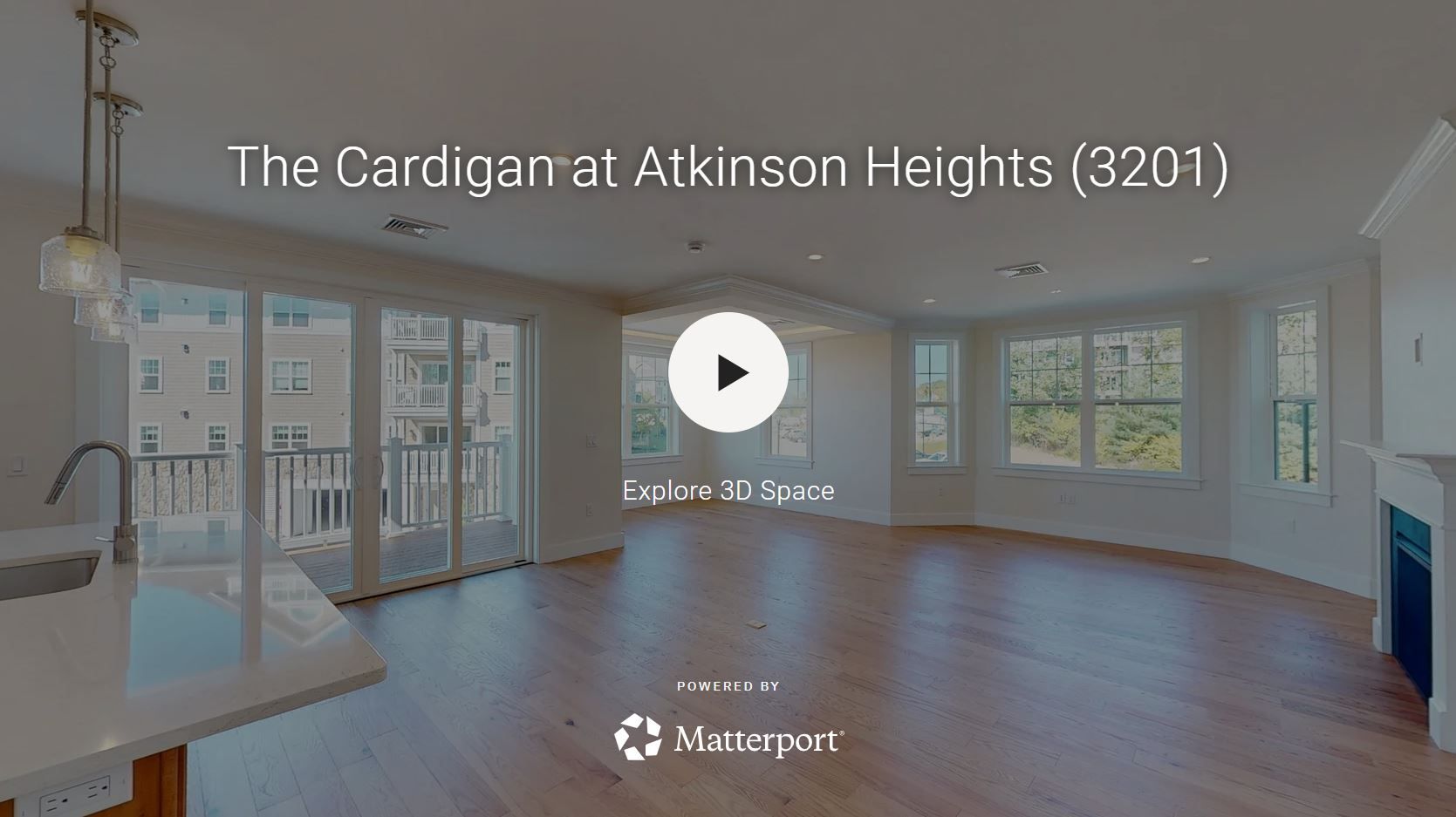 Interior view of a living space with wooden floors, sliding glass doors, and a fireplace.