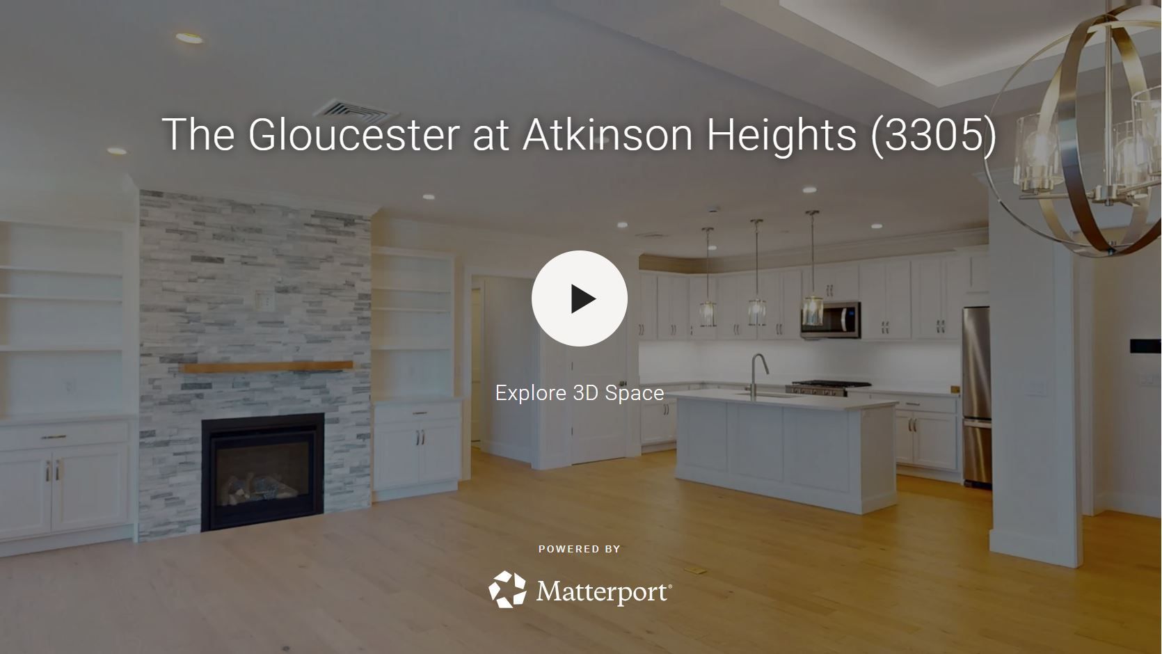 Interior view of a modern living area with fireplace, white cabinetry, and a kitchen island.