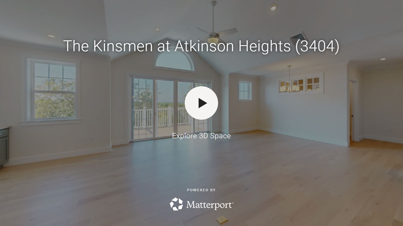 Interior view of a room with engineered hardwood floors, large windows, and an arched doorway.