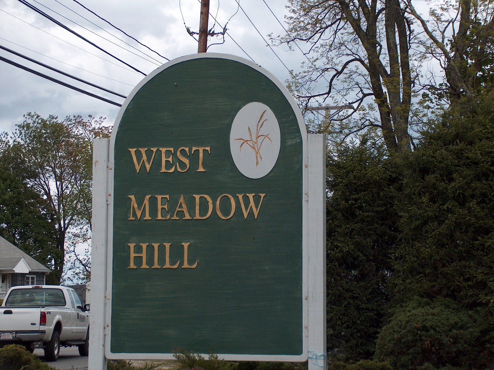 A green and white sign for west meadow hill