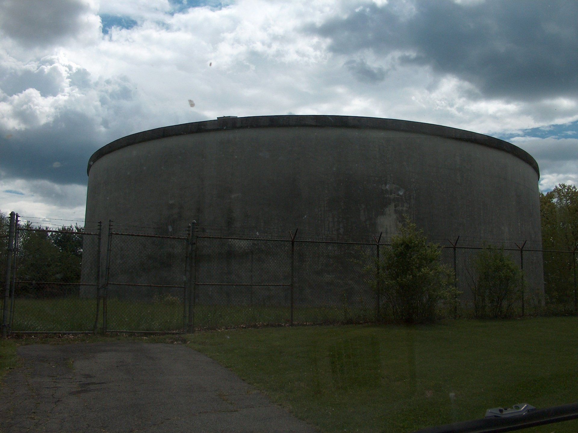 A large concrete water tank with a fence around it