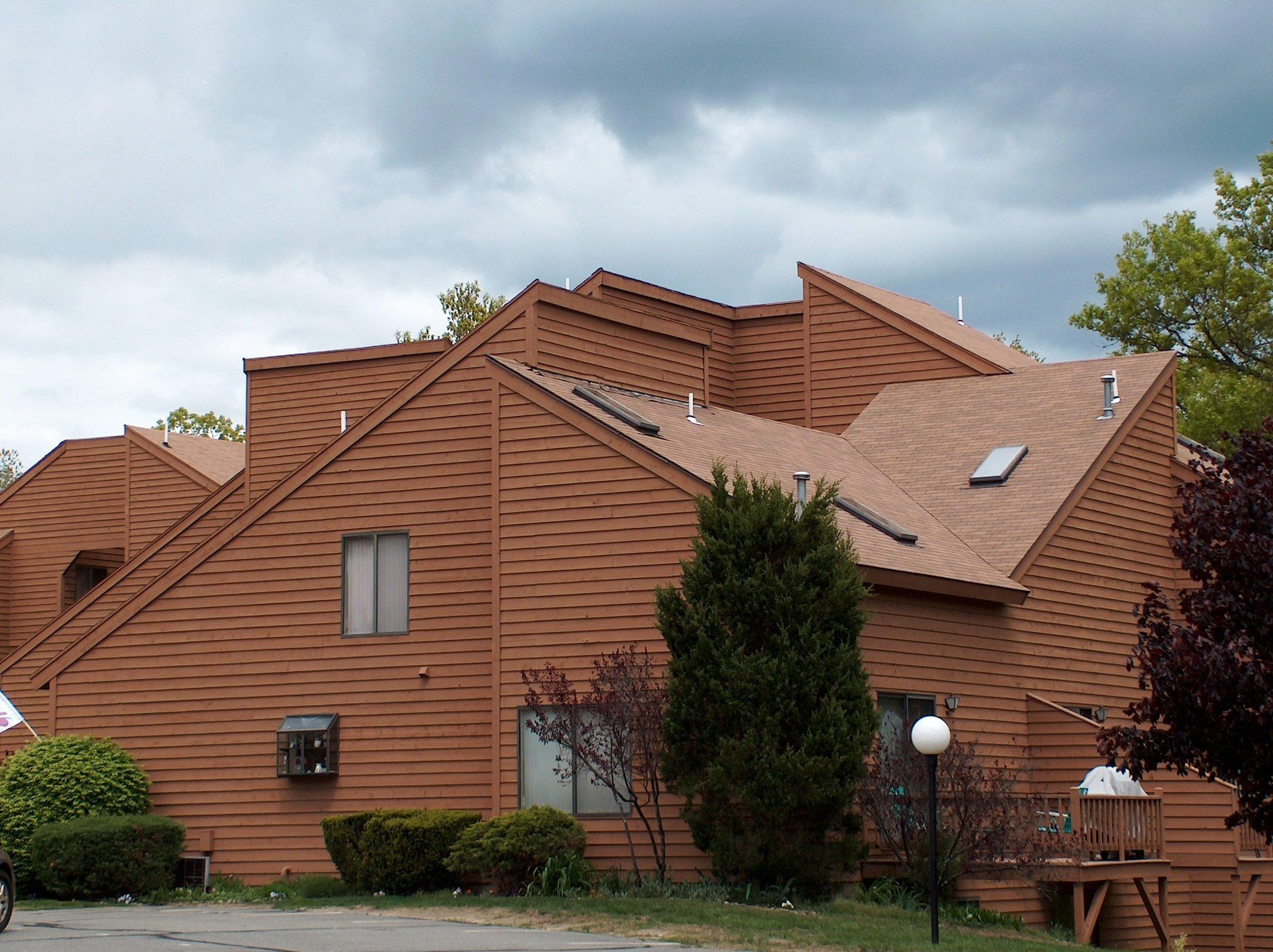 A large brown house with a roof that has a skylight on it