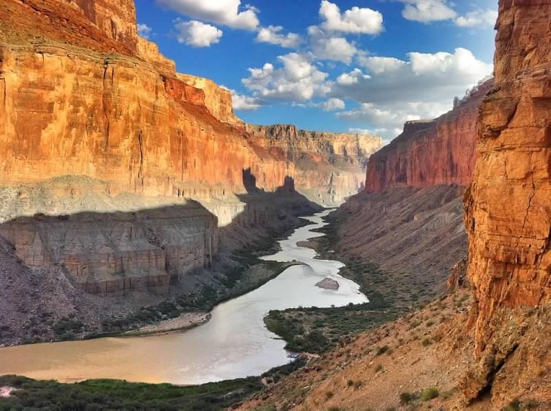 A river runs through a canyon between two rocky cliffs.