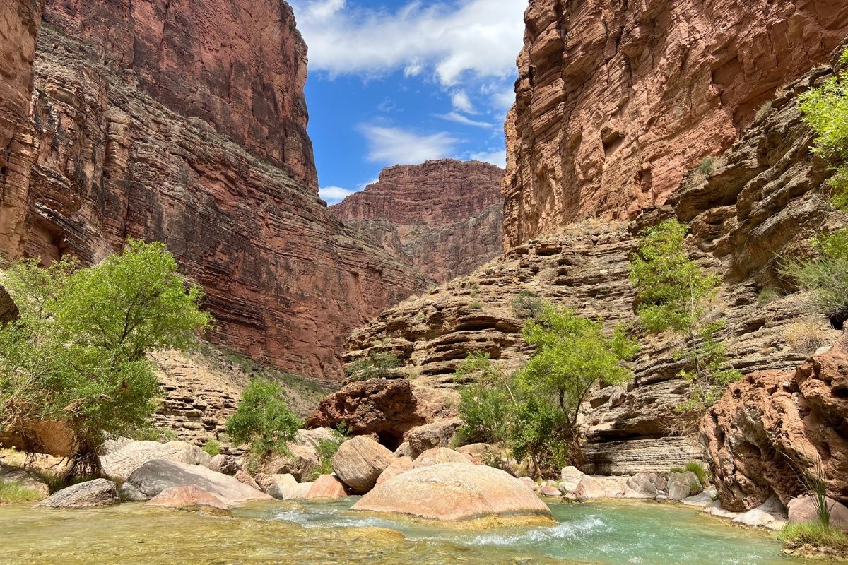 A river flowing through a canyon surrounded by rocks and trees.