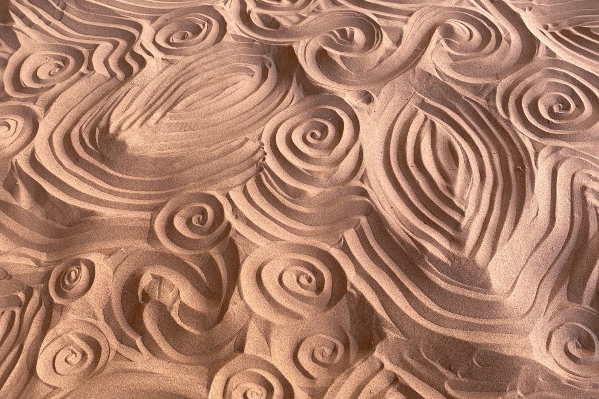 A close up of a sand sculpture with swirls on it