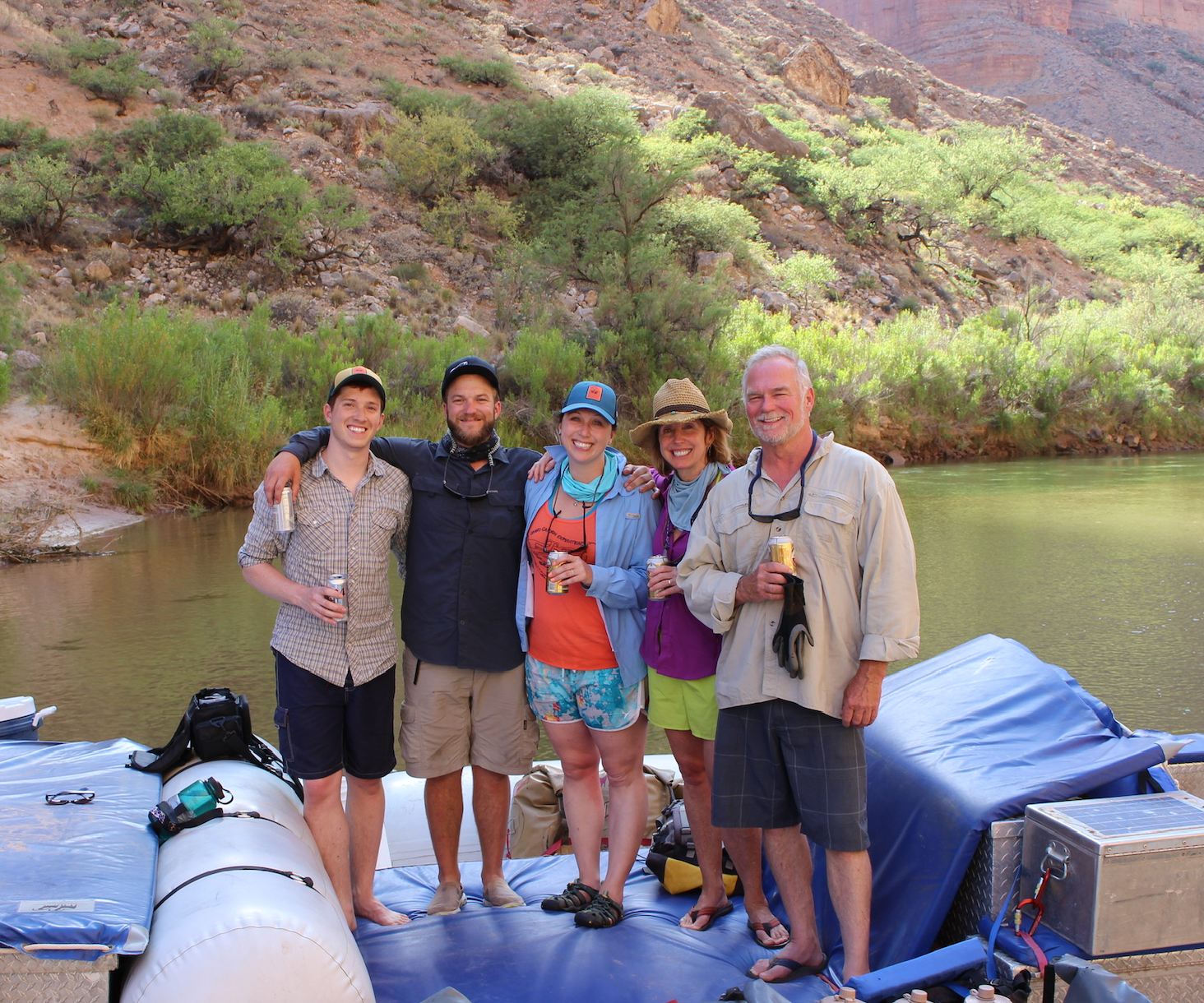 A group of people are posing for a picture in front of a mountain.