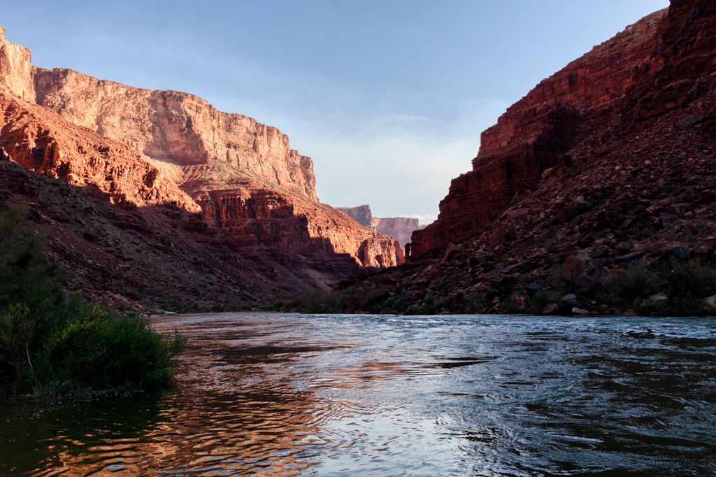 A river flowing through a canyon with mountains in the background