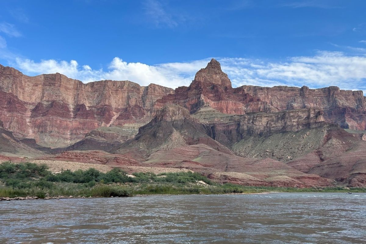 There is a large mountain in the background and a river in the foreground.