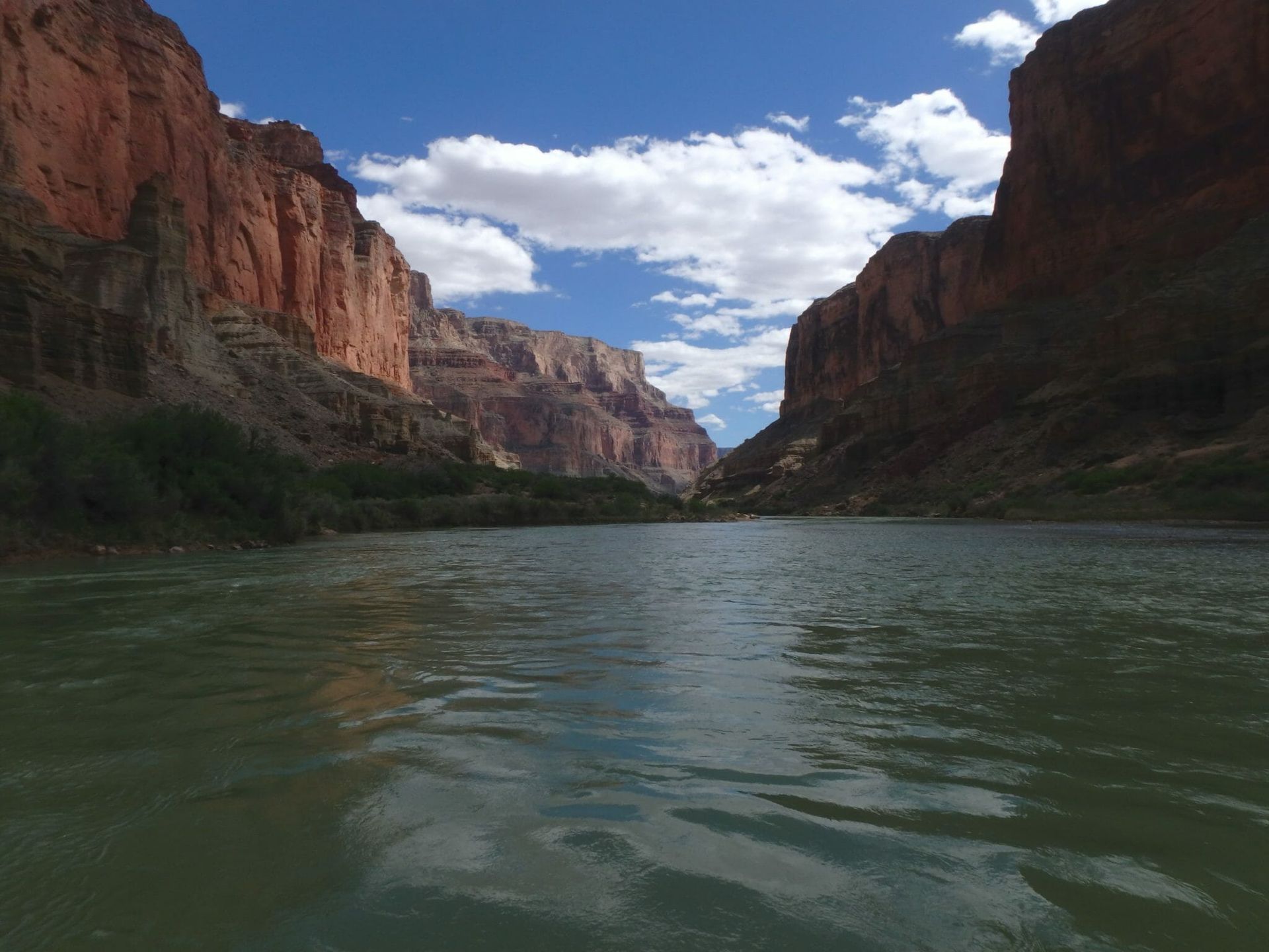 A river flowing through a canyon with mountains in the background