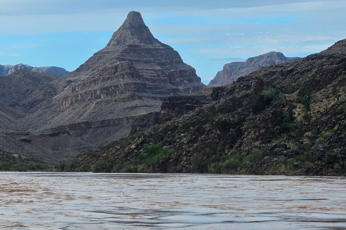 There is a mountain in the background and a river in the foreground.