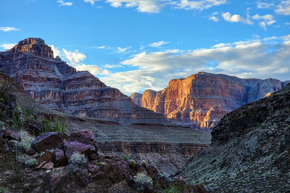 The sun is shining on the mountains in the grand canyon.