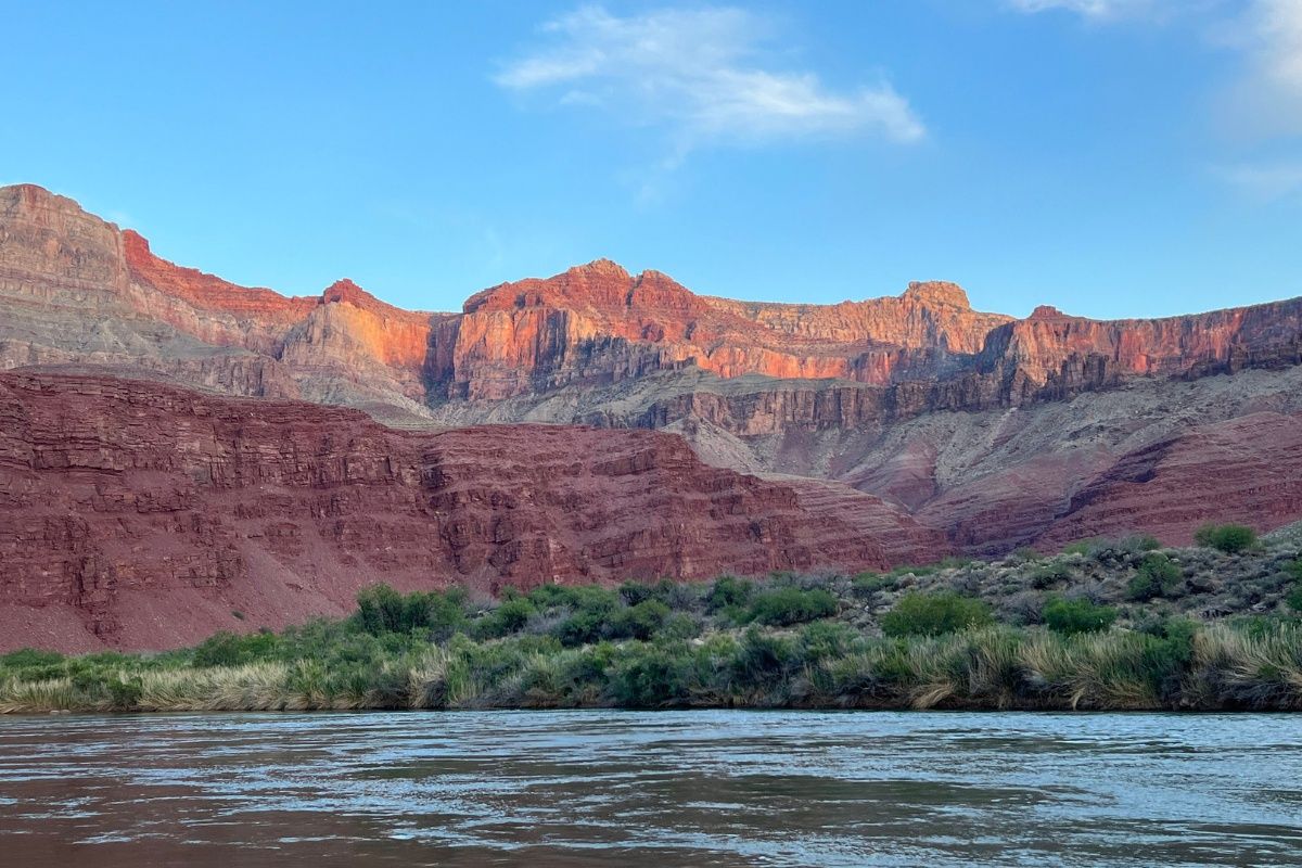 A river flowing through a canyon with mountains in the background.