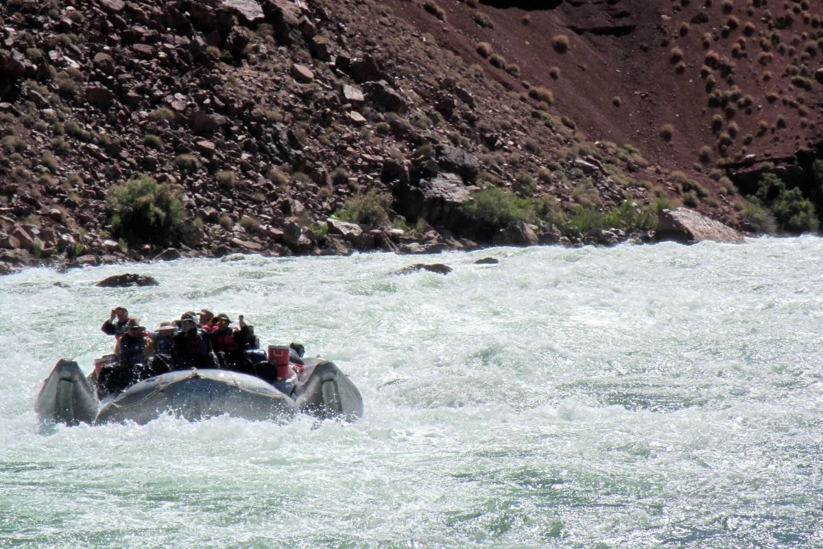 A group of people are in a raft on a river