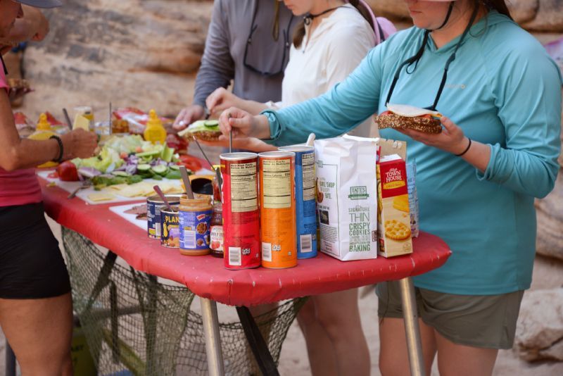 A group of people are standing around a table eating food