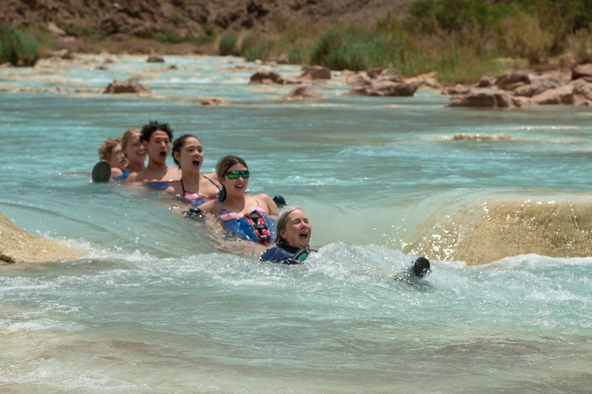 A group of people are swimming in a river.