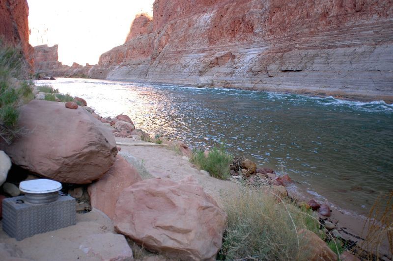 A river runs through a canyon next to a rocky cliff.