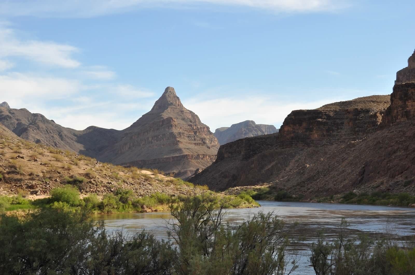 A river runs through a canyon with mountains in the background