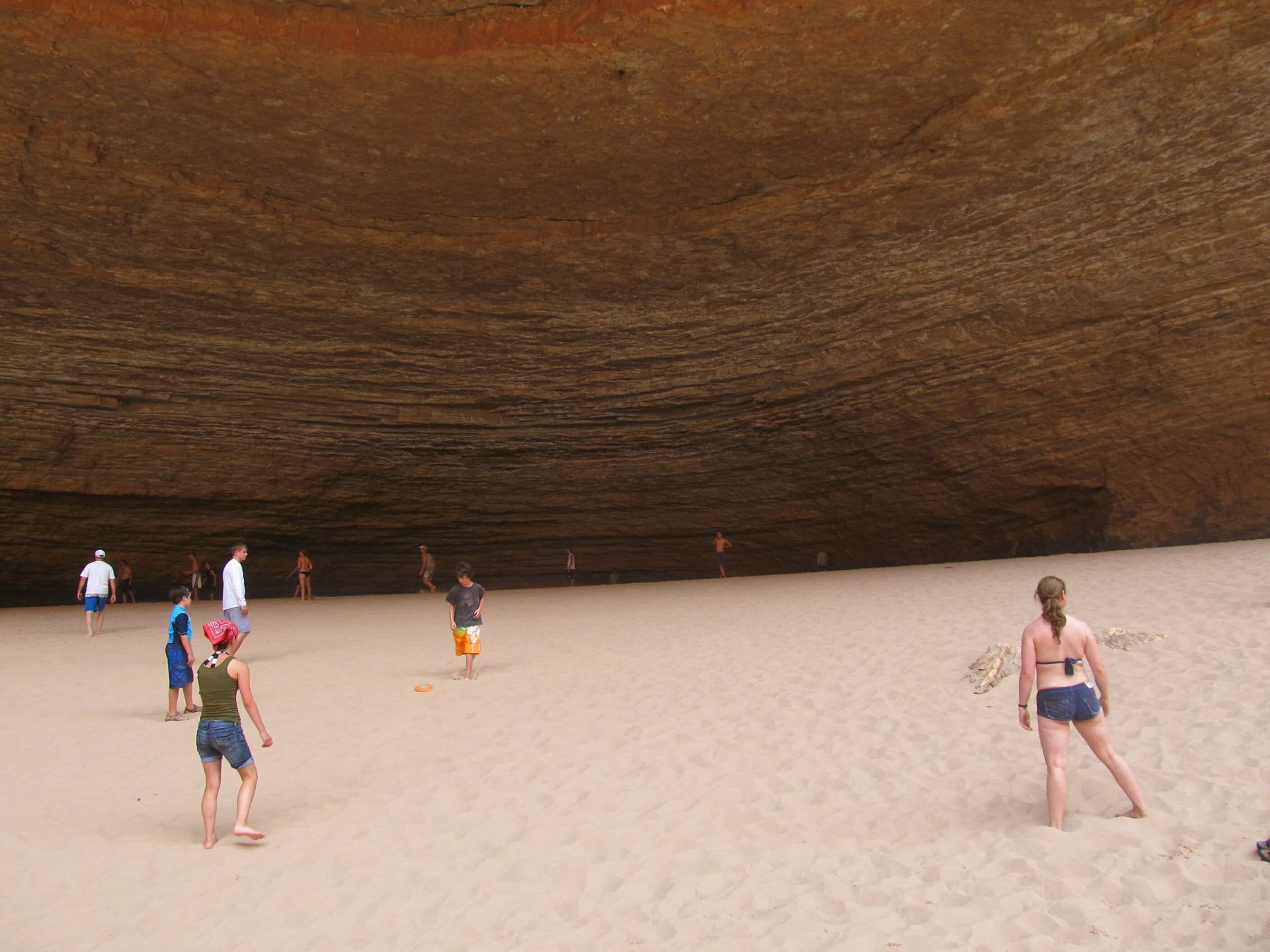 A group of people are playing volleyball on a sandy beach